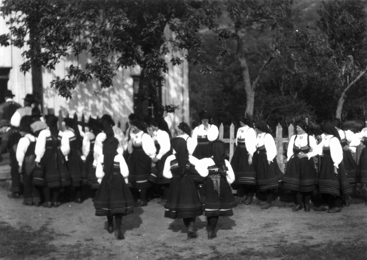 Bryllup, Valle, Setesdal, Aust-Agder, antatt 1924. Kvinnegruppe ved gjerde på vei inn i våningshus.. Fra "De Schreinerske samlinger" (skal oppgis).