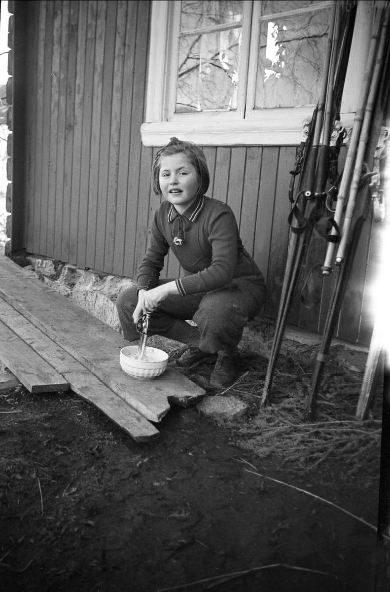 Guri Arentz sitter utenfor hytta og pisker krem. Gol påsken 1939.