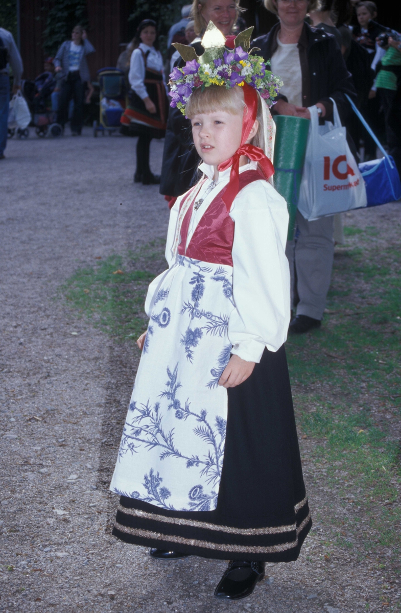 St. Hansaften og jonsokbryllup på Norsk Folkemuseum 2004. Margrete i drakt med søljer på skjorten. På hodet har hun både krone og blomsterkrans.