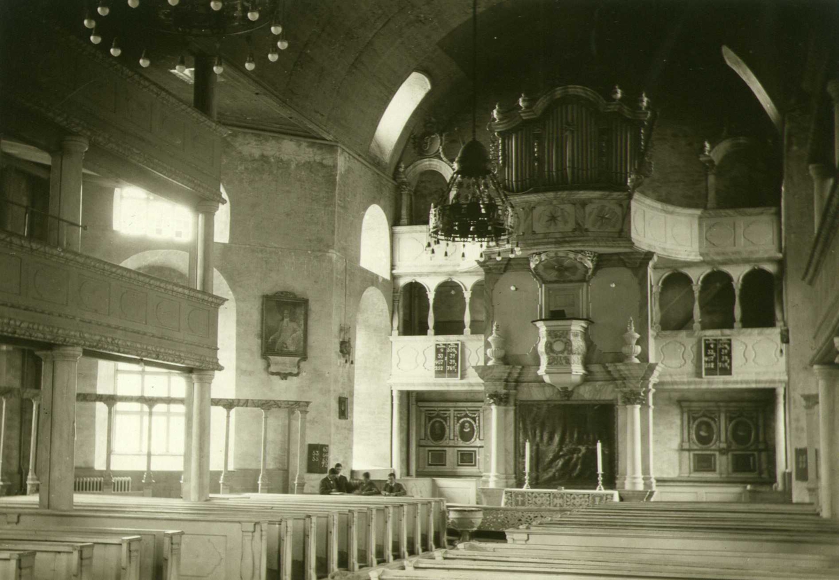Interiør med alter, prekestol og orgel, Røros kirke, Røros, Sør-Trøndelag. Fire unge menn ved siden av alteret (Johan Meyers elever?). Fotografert 1916.