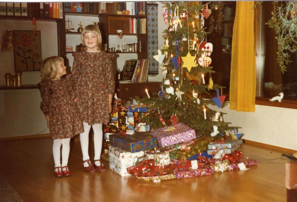 To jenter i brune kjoler ved juletre, julen 1978.