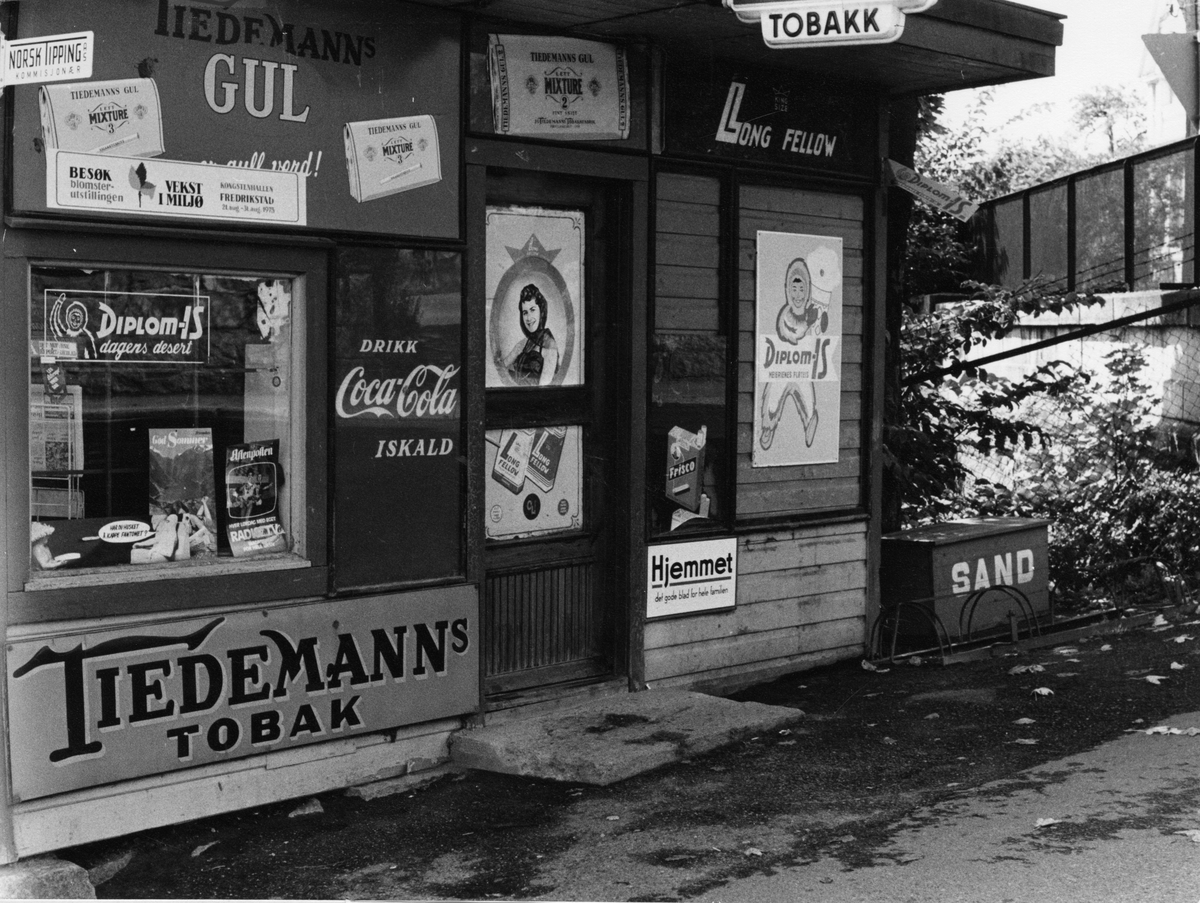 Kiosk med reklameskilt for tobakk og Diplom-is.