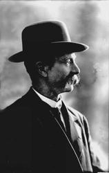 Portrett, mann med dress, stor bart og hatt. Hr Semb.