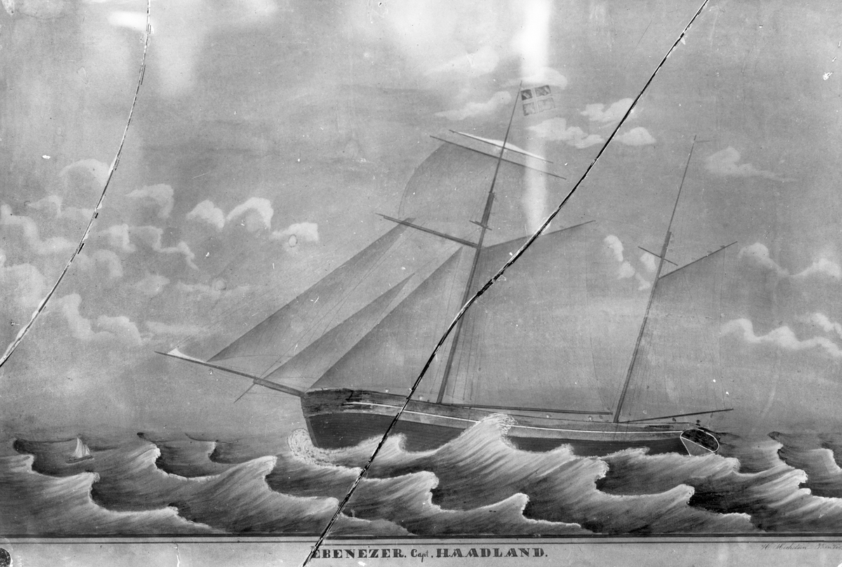 Avfotografert maleri av Galeasen "Ebenezer" i store bølger. En liten robåt ligger på siden av akterenden. Glassplata er knust.