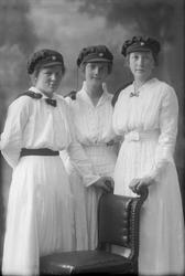 Gruppeportrett, tre jenter med studentlue. Frøken Teiste.