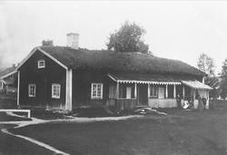 Avfotografering. Lang og smal tømmerstue, panelt, med torvta