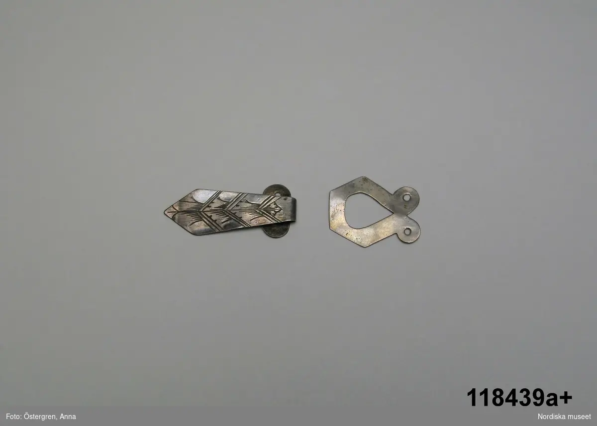 Huvudliggaren:
"Tröjhäktor (hyskor och hakar), 3 par och 1 hyska, av silver, graverad ornering. Skåne.
Gåva 31/12 1912 Kjellberg, Zelma och Teresa, Fröknar samt Adolf, Herr, Stockholm.