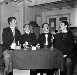 Utkledde menn sitter rundt bord. Oslo 02.05.1959.