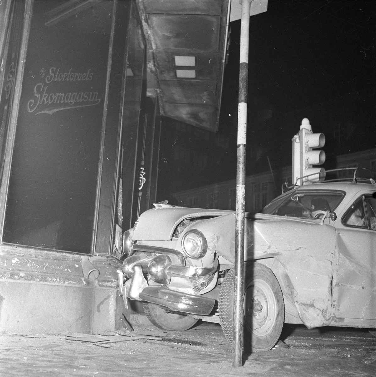 En bil av typen amerikansk Ford 1951 modell har kjørt inn i en skoforretning på Stortorget i Oslo, 04.07.1956.