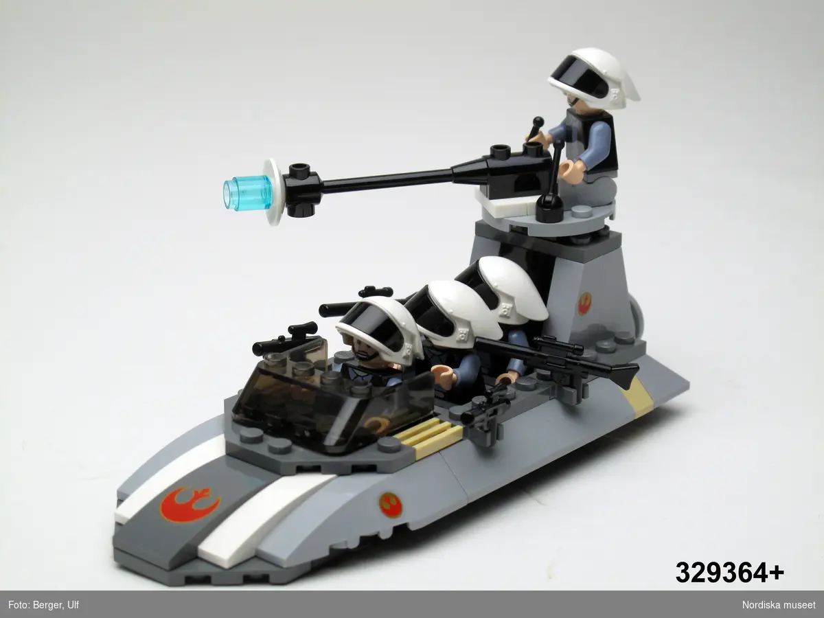 Legomodell - där plastdelar genom standardiserade upphöjningar kan monteras i varandra - i Star warsserien som föreställer en med fyra krigsmän och vapen bestyckad platt, båtformad stridsvagn utan hjul/svävare som drivs av en jetmotor. Stridsvagnen är bestyckad med vridbar kanon och fyra kulsprutor. Krigsmännen är hjälmförsedda. 

Föremålet inköpt till museets som byggsats vilken monterats den 16/5 2008 av Simon och Oscar Sällström Stockholm. I Legos Star Warsserie har byggsatsen nummer "7668".

LEGO har tillverkat en mängd olika Star wars-figurer under de senaste åren. 

Star Wars (Stjärnornas krig) är en serie amerikanska filmer, (den första kom 1977 och hittills har 6 st utkommit) som utspelar sig i en avlägsen framtid ute i rymden. Filmerna har varit mycket populära och mängder av kringprodukter som spel, datorspel, olika leksaker m.m. har producerats. Även tv-serier har gjorts.

Se originalförpackning inv.nr 329.365

Föremålet inköpt för att rekonstruera julklappsönskemål julen 2007 från Lukas Thomsson, född 1999, Vaxholm. Inköpt av Nordiska museet för 149,50 kr 2008. Ingår i projektet "Barn tar plats". Se dokumentation i arkivet D455.
/Ulf Hamilton 2008-05-27    
