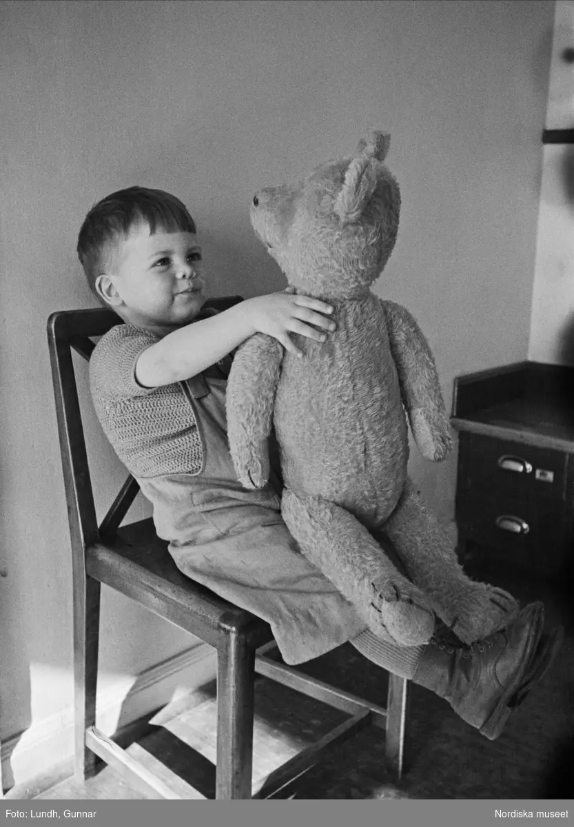 Barn. En pojke håller i en stor nallebjörn. Lekstugan i HSB:s hus i Kvarteret Marmorn på Lundagatan, Södermalm, Stockholm.