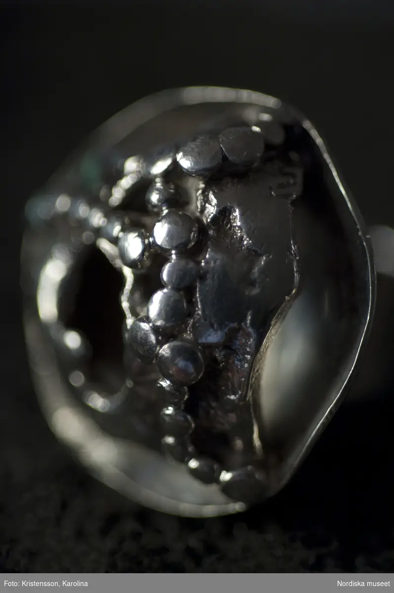 Ring tillhörande Margareta Persson, ringen är sannolikt ritad och utförd av Bernd Janusch, men stämplad med Rosa Taikons stämpel.
ring; silver; smycke; filigran-teknink