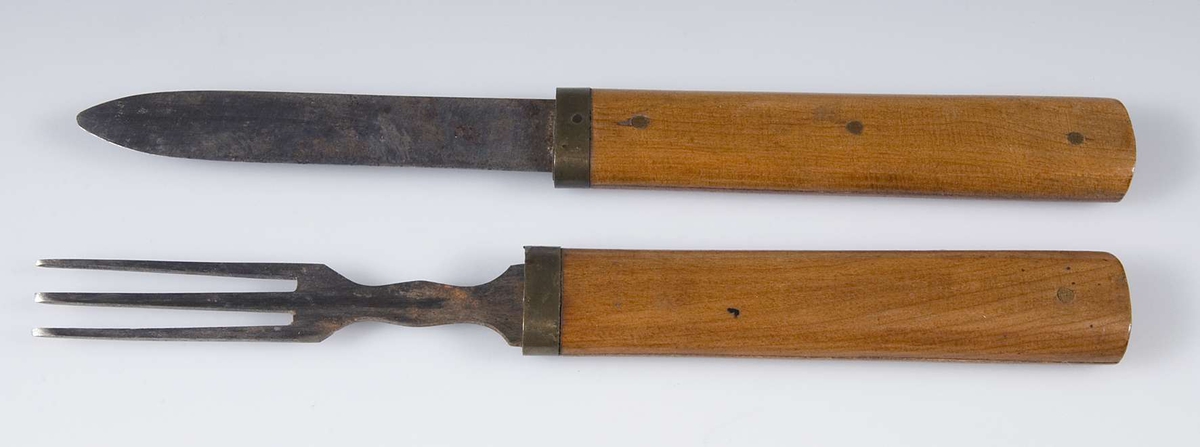 Kniv och gaffel av järn med träskaft, kan skjutas i varandra.


