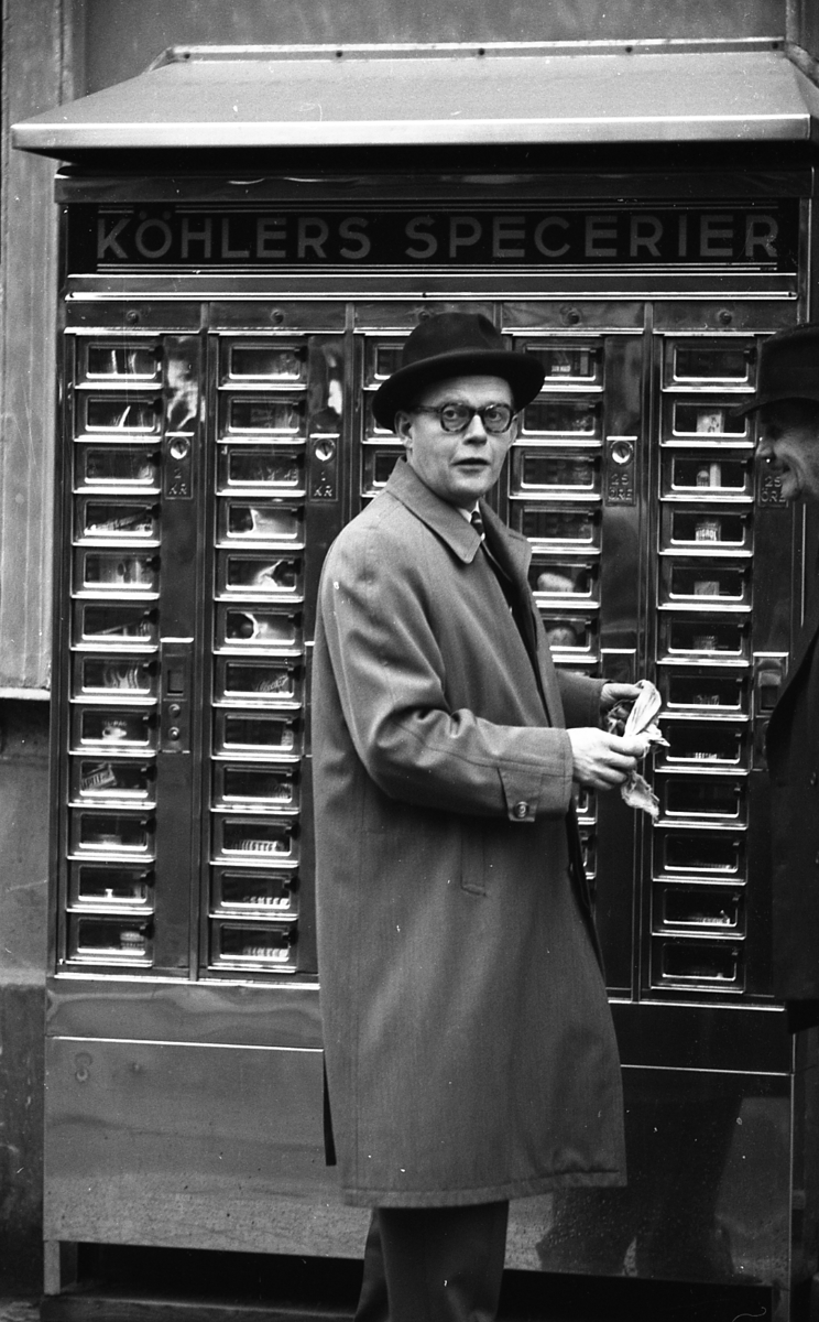 Köpmannen Fredrik Köhler vid automaten utanför delikatessaffären på Sysslomansgatan 2, Uppsala 1961