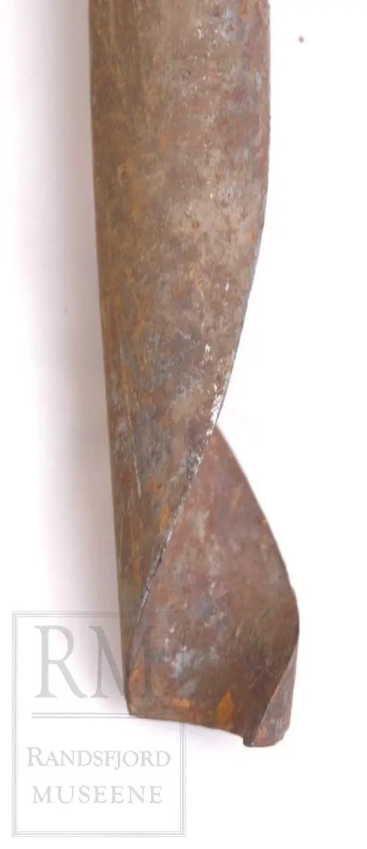 Bor av smidd jern, med tverrstilt håndtak av tre i motsatte ende.