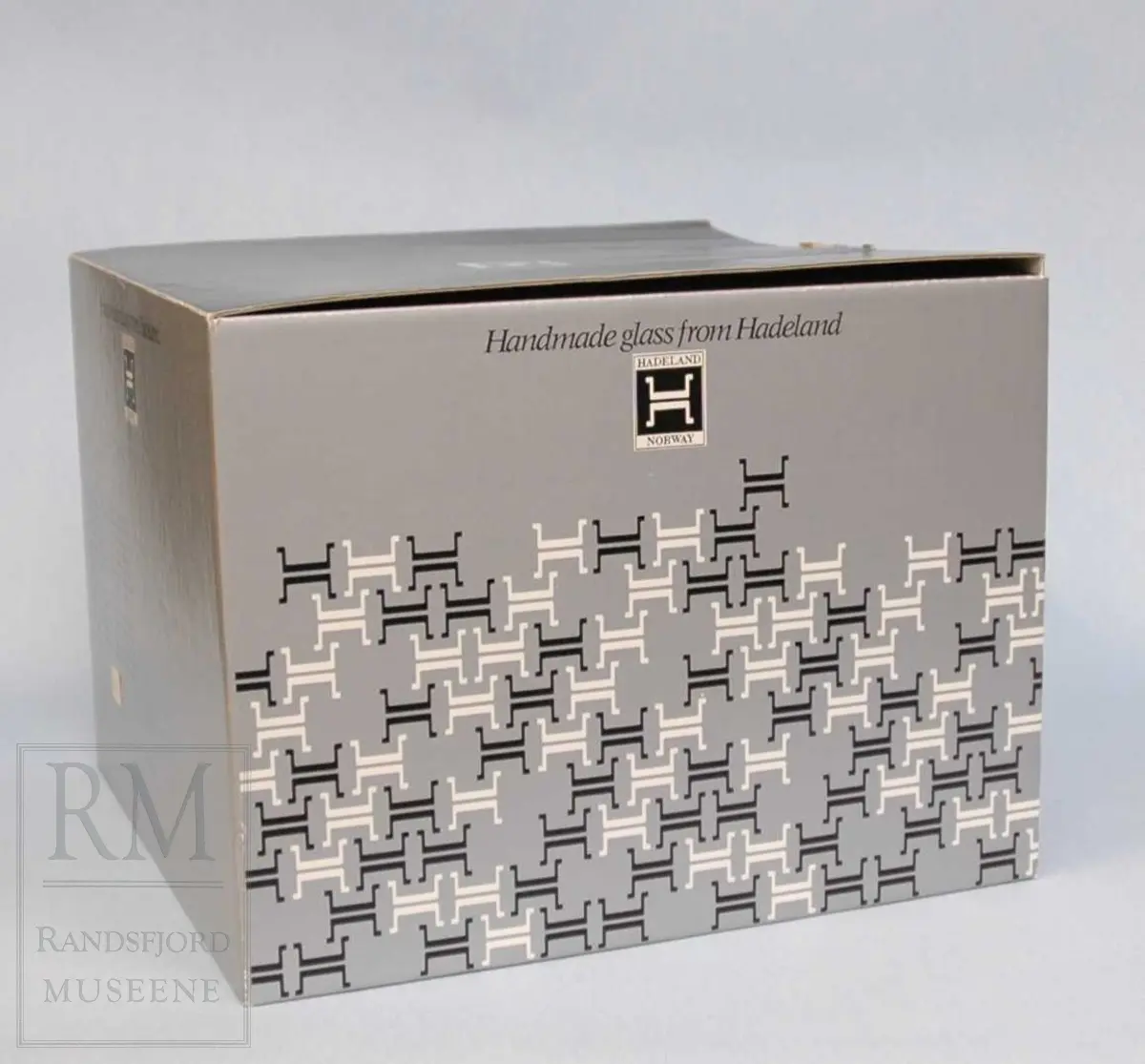 Hvit bolle, med gule bølgelinjer. 
Grå/svart orginalemballasje. 