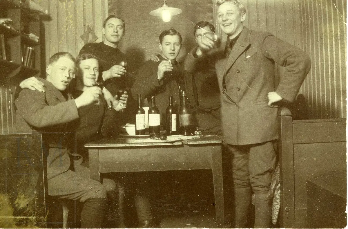 6 menn rundt et bord skåler med brennevin