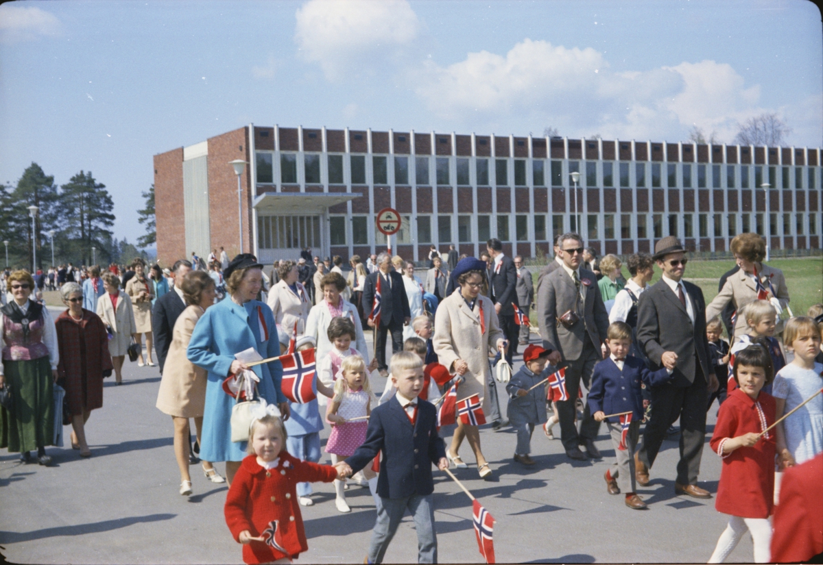 17. mai, Elverum. 1970. Ved ungdomsskolen / nye folkvang. Barn og voksne med flagg(Småbarnetog?)