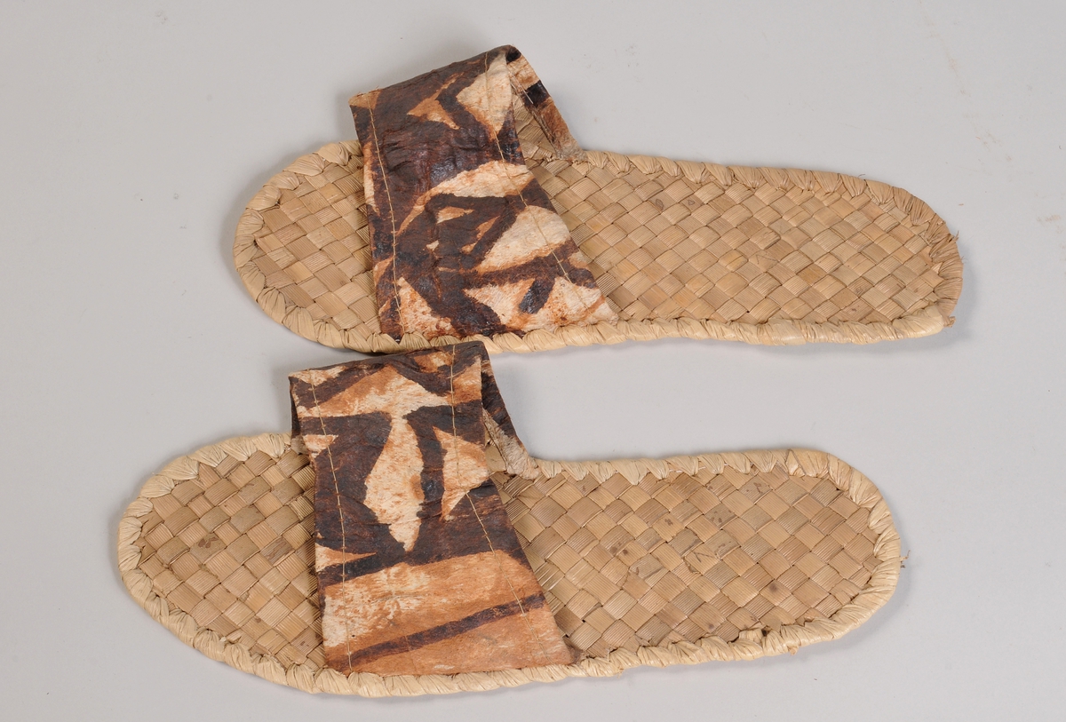 Sandaler i flettet bast med dekorert skinnforsterkning på fotstroppen.