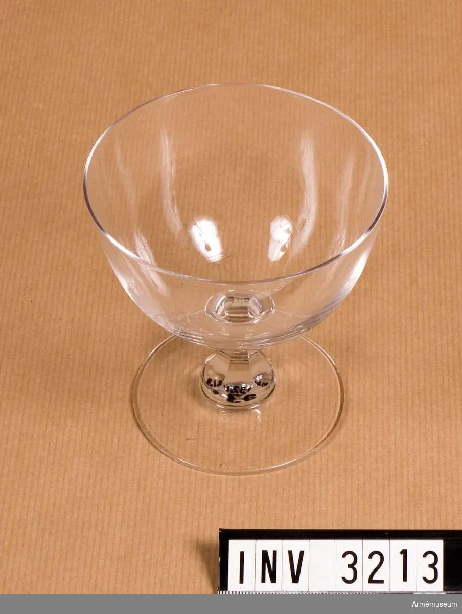Av kristallglas med etsat vapen i form av en krönt, halverad sköld med folkungalejonet. Användes till champagne m m.
