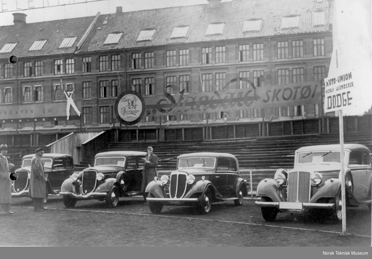 Bilutstillingen i på Frogner stadion i 1934. Wanderer og Dodge biler. I bakgrunnen reklame for Standard Skotøy.