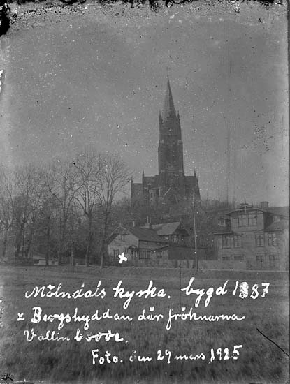 Enligt text på fotot: "Mölndals kyrka, bygd 1887 x Bergshyddan där fröknarna Vallin bodde. Foto den 29 mars 1925".