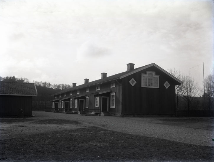 "1930. 24. Baracken arbetarbostad vid Munkedals fabrik."

"Huset innehöll åtta bostäder. Huset revs på 1960-talet. Vedbod till vänster."
