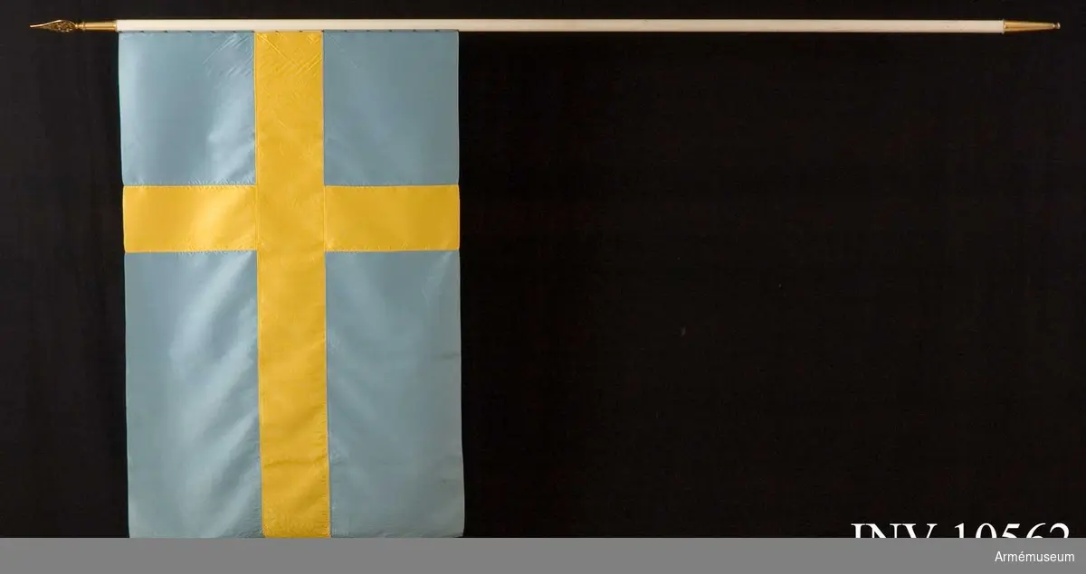 Grupp B I.

Duk av blått och gult siden, s k korsflagga. Fodral av blått kläde är märkt på den undre fickan: "Int 2". Fickan innehåller spetsen med Gustav V:s namnchiffer.