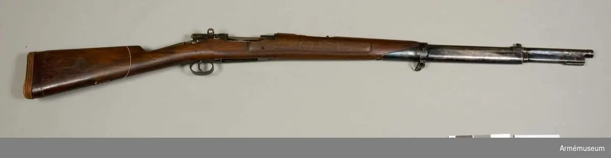 Grupp E IV e.
Halvautomatiskt gevär. Försök till förändring av gevär m/1896 till automatgevär. 1940-tal. Kaliber 6,5 mm. Stocken delvis förändrad. Magasin saknas. Okänd konstruktör. Tillverkningsnummer 446564. 