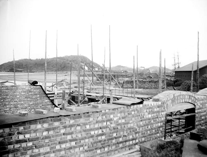 Byggandet av ett oljeslageri i Uddevalla hamn hösten 1898.
"Fönsterhvalfven slås."