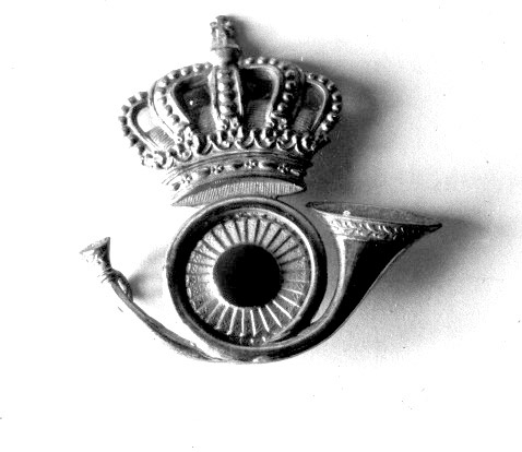 Mössmärke bestående av ett högervänt krönt posthorn med en nationalkokard i posthornets slinga. Mösstecknet användes på släpuniform för vaktbetjänter (brevbärare och brevlådetömmare).