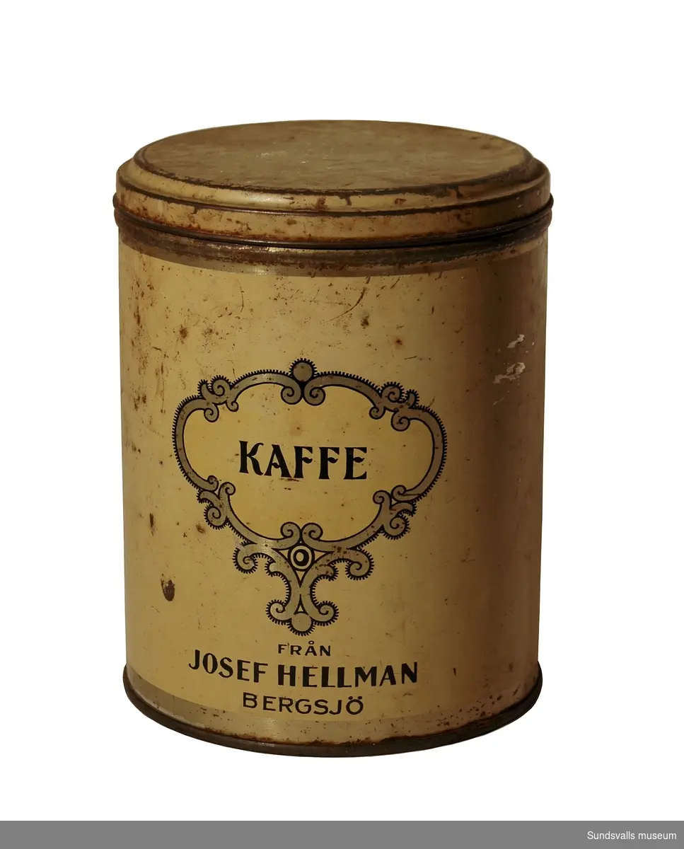 Rund gul kaffeburk med dekoration och text i svart och guld. Texten lyder 'KAFFE FRÅN JOSEF HELLMAN, BERGSJÖ'.