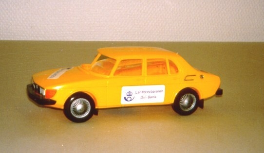 Sparbössa, utformad som en lantbrevbärarbil av modell SAAB
99. Bilen tillverkad av plast i Finland 1979, efter en idé från
lantbrevbärarna i Vingåker. På bilen sitter reklam dekaler på fram-
och bakluckorna, samt dörrar. I taket finns myntspringan. Sparbössan
var avsedd som gåva till de kunder som genom lantbrevbärare öppnade
nya konton under en kampanj, anordnad av PK-banken veckorna 40-45,
1979.