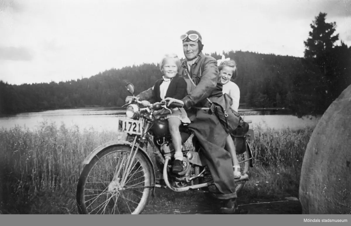 Arvid Svensson har en lättviktare model 98cc Rex, som han tar sig till jobbet med, vid hemresan tar han upp barnen på åktur, 1949. Då räckte en skinnluva som skydd för huvudet. 
Margareta Nordin var sommargäst på Långö.