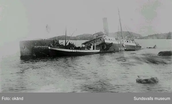 Ångaren "Alsterdam" har lidit skeppsbrott vid Kråkskäret (vid Grisslan) på 1930-talet. Fiskebåten i förgrunden är förmodligen "Hanna", hemmahörande i Barsta på Nordingrå, innanför Högbonden.