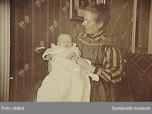 Text på fotografiets baksida: "Karl Henrik Wåhlstedt, född den 13 Sept. 1906. med sin mamma och Moppe. Taget den 27 Jan. 1907. Östersund"