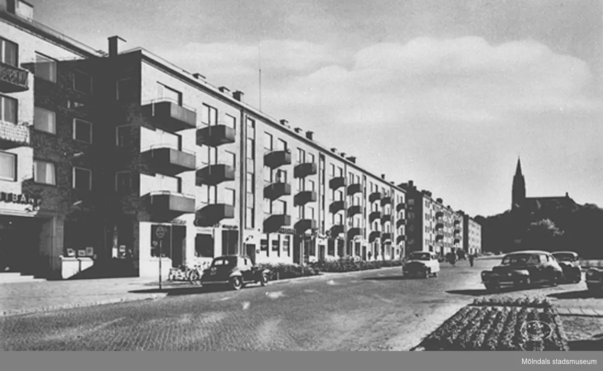 Vy över Kyrkogatan (nuvarande Tempelgatan) från nordost. Husen uppfördes i slutet av 1940-talet och gatan bytte namn 1954. 

Mölndal. Kyrkogatan. ÄKTA FOTOGRAFI   A-B Jolin & Wilkenson. Göteborg.