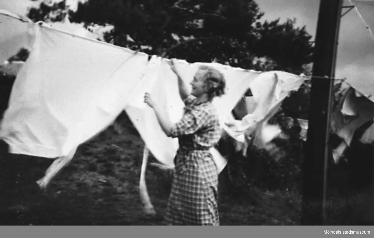 Rosa Krantz (gift Pettersson) hänger tvätt utanför personalbostaden på Stretered, 1922-1925.