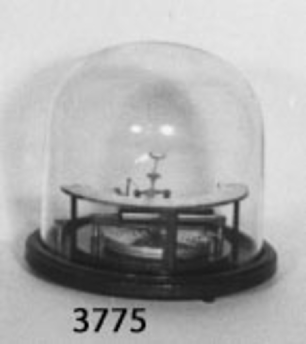 Barometer, aneroid-, med skala 727-792 mm på fot av grönmålat järn i form av en cirkelring, täckes med kupa av glas.