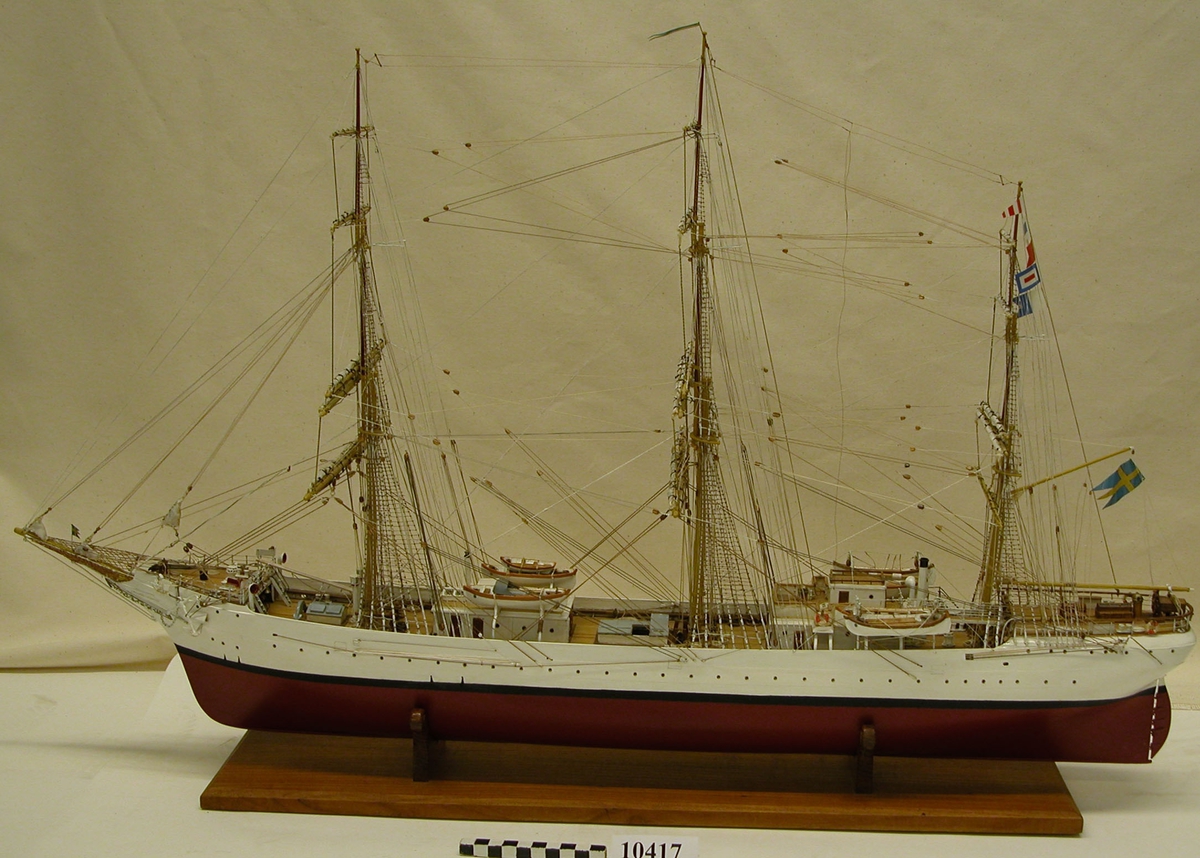 Fartygsmodell av övningsfartyget af Chapman, utförd i trä, komplett riggad samt beslagna segel. Fartygets namnsignal hissad på mesanmasten. Modellen vilar på skrån av teak.