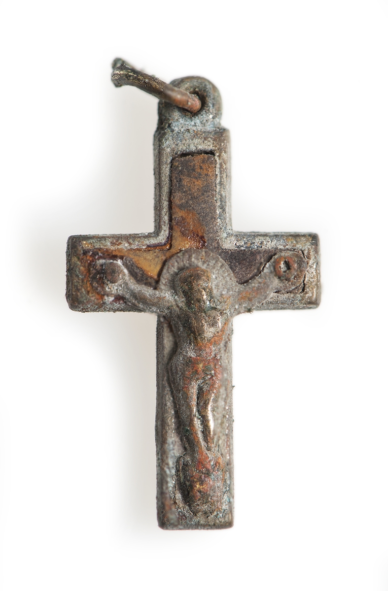 Berlock, krucifix, som låg i myntbörsen (a).Föremålets form: kors