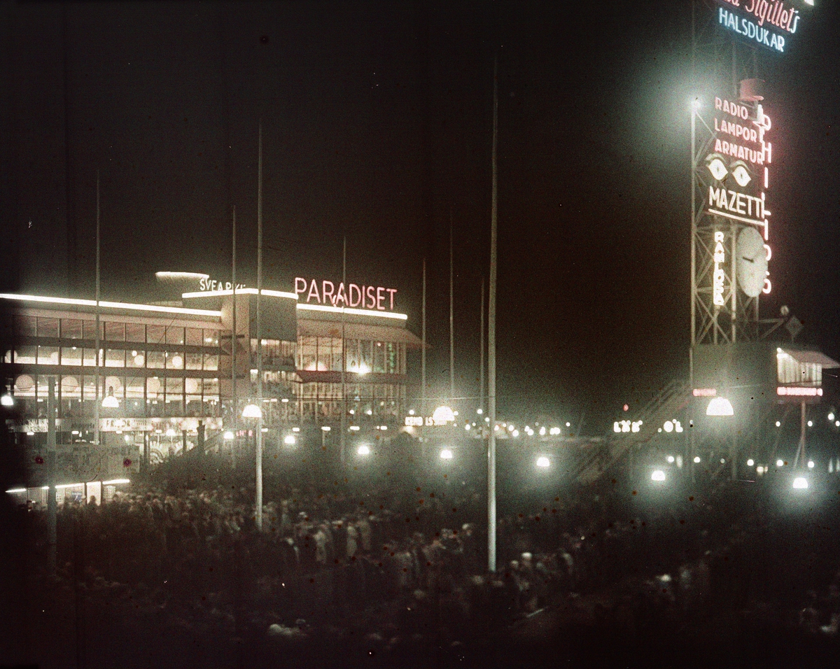 Restaurang Paradiset och masten med pressläktaren i neonbelysning. Nattbild. Arkitekt till Paradiset: Gunnar Asplund, arkitekt till masten: Sigurd Lewerentz.
Stockholmsutställningen 1930