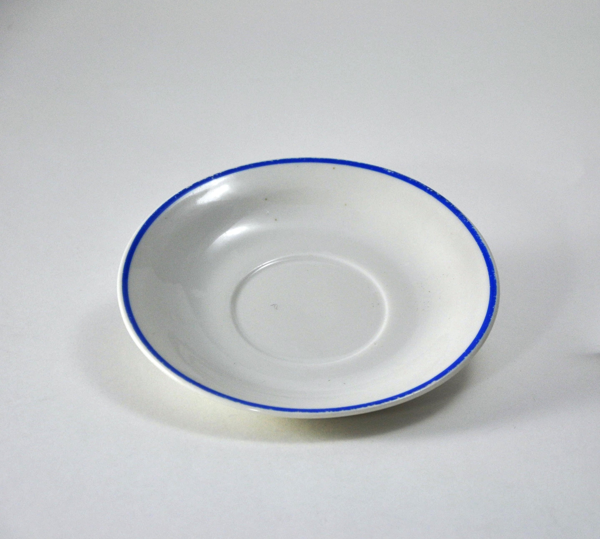 Liten skål i hvit porselen med blå munningsrand.