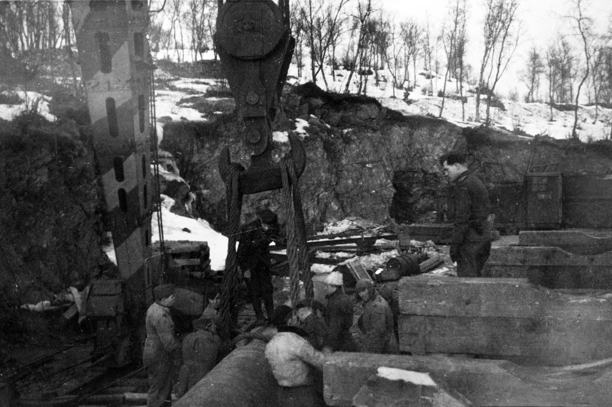 Tyske soldater og russefanger arbeider med lossing av tungt utstyr.