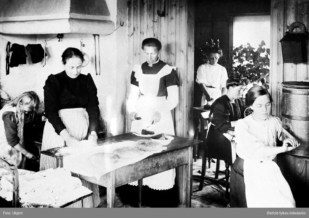 Tukkun, begravelsesforberedelser på kjøkkenen (Øst-Tukken) i Rømskog 1915.
Fra venstre: Ester Ringsby, Hanna Ringsby, Frida Ringsby, to svenske jenter inenfor døre til siderommet, Olga Ringsby.