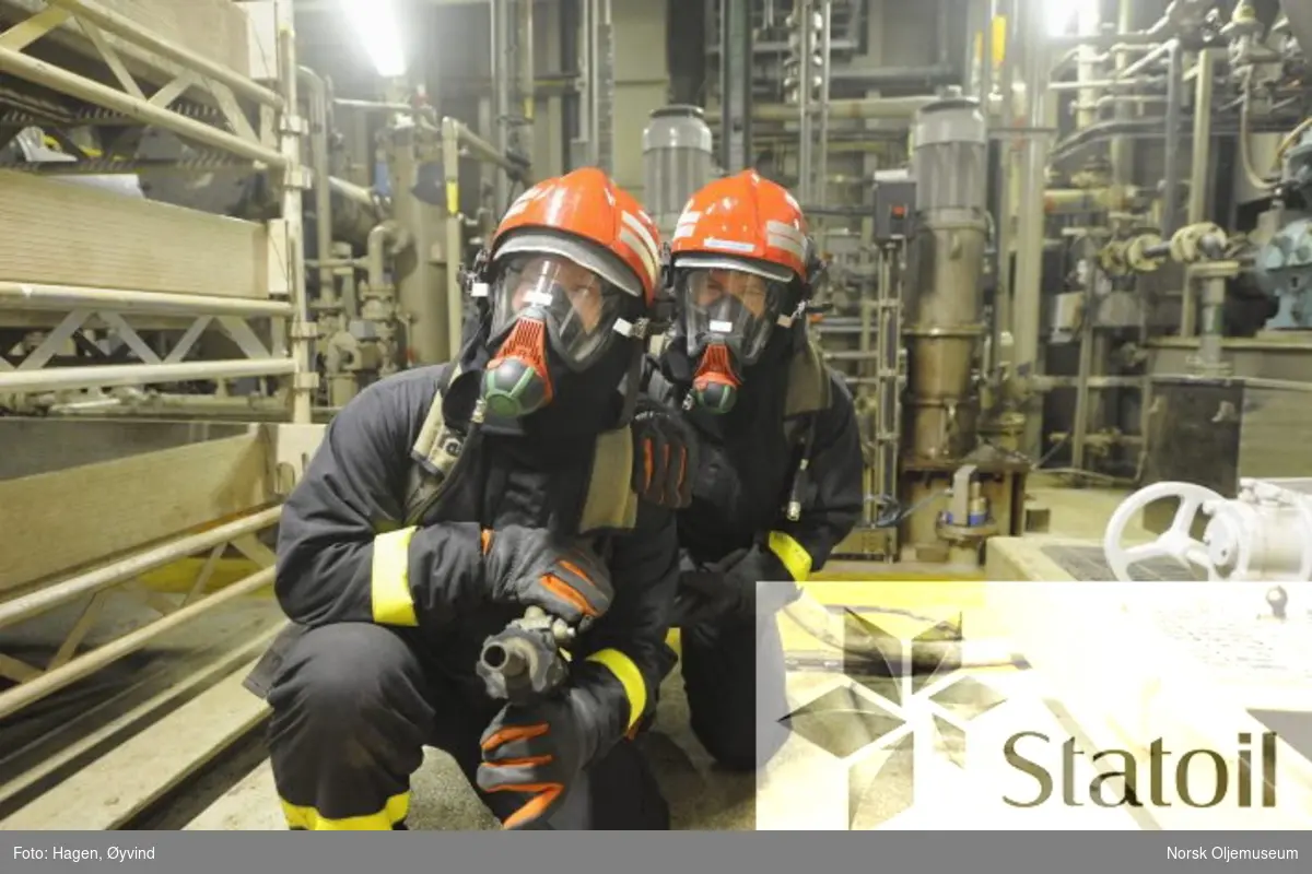 Beredskapsøvelse på Statfjord C.  To personer utstyrt med pusteluft  og verneutstyr er klar med brannslange.