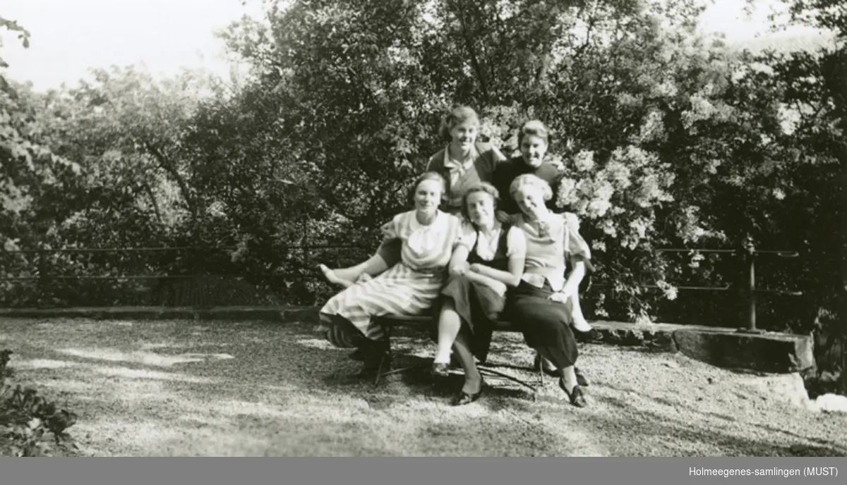 Fem unge kvinner i en hage.