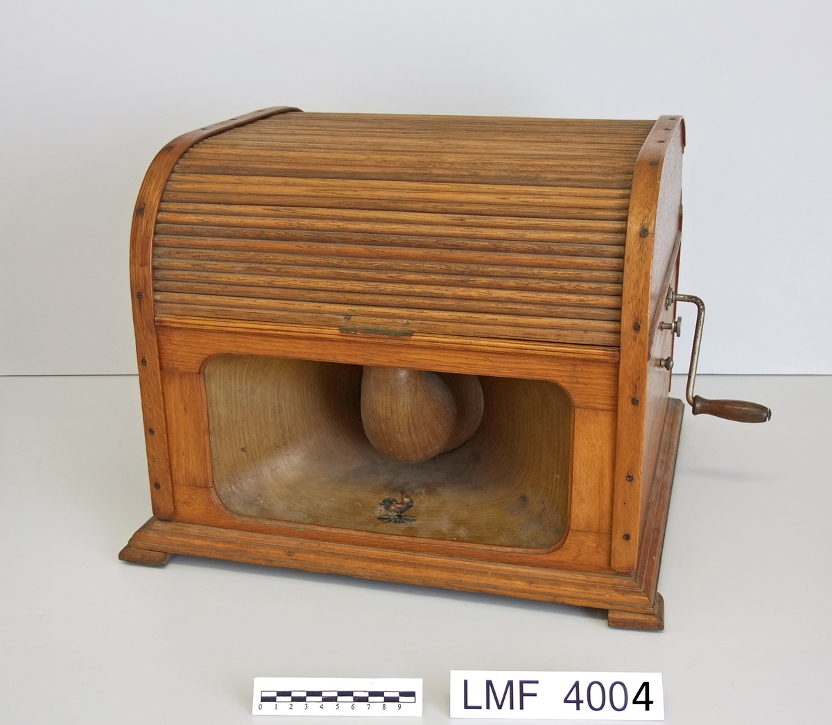 På nedre del av "høyttaleren":  en hane  (oppå en grammofonplate).