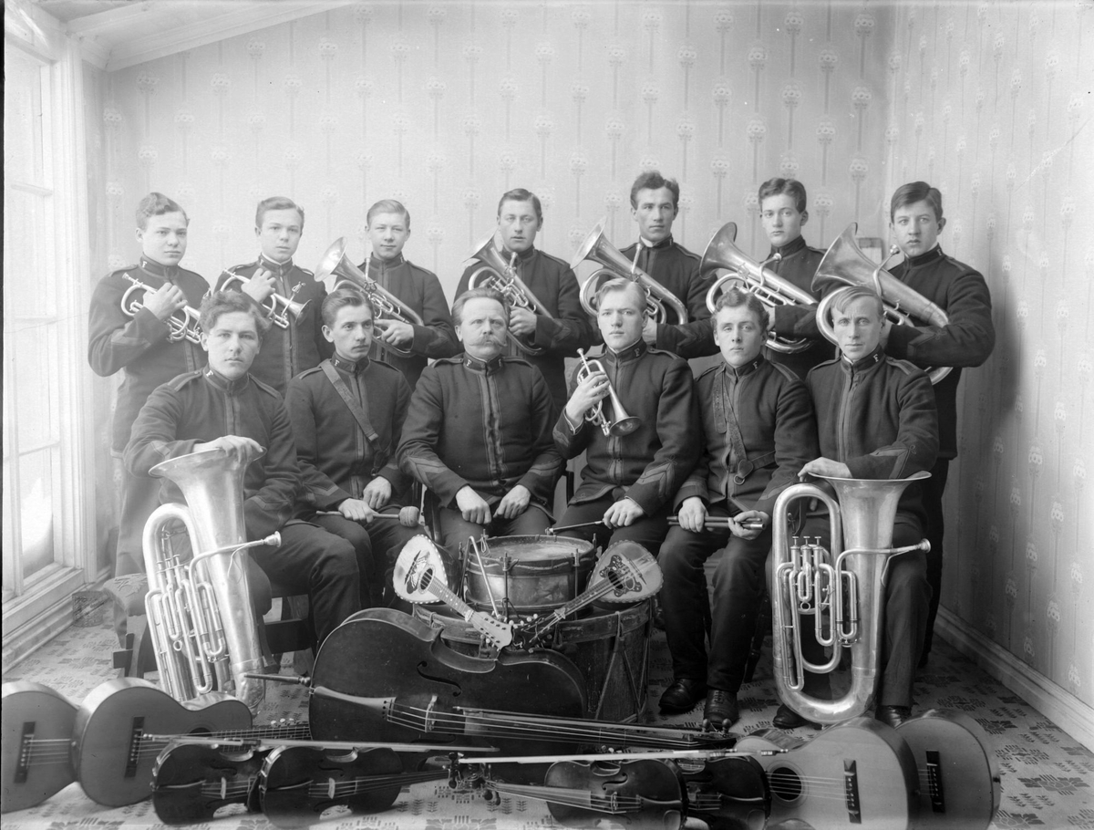 Studioportrett av en gruppe frelsesarmémusikanter med instrumenter.