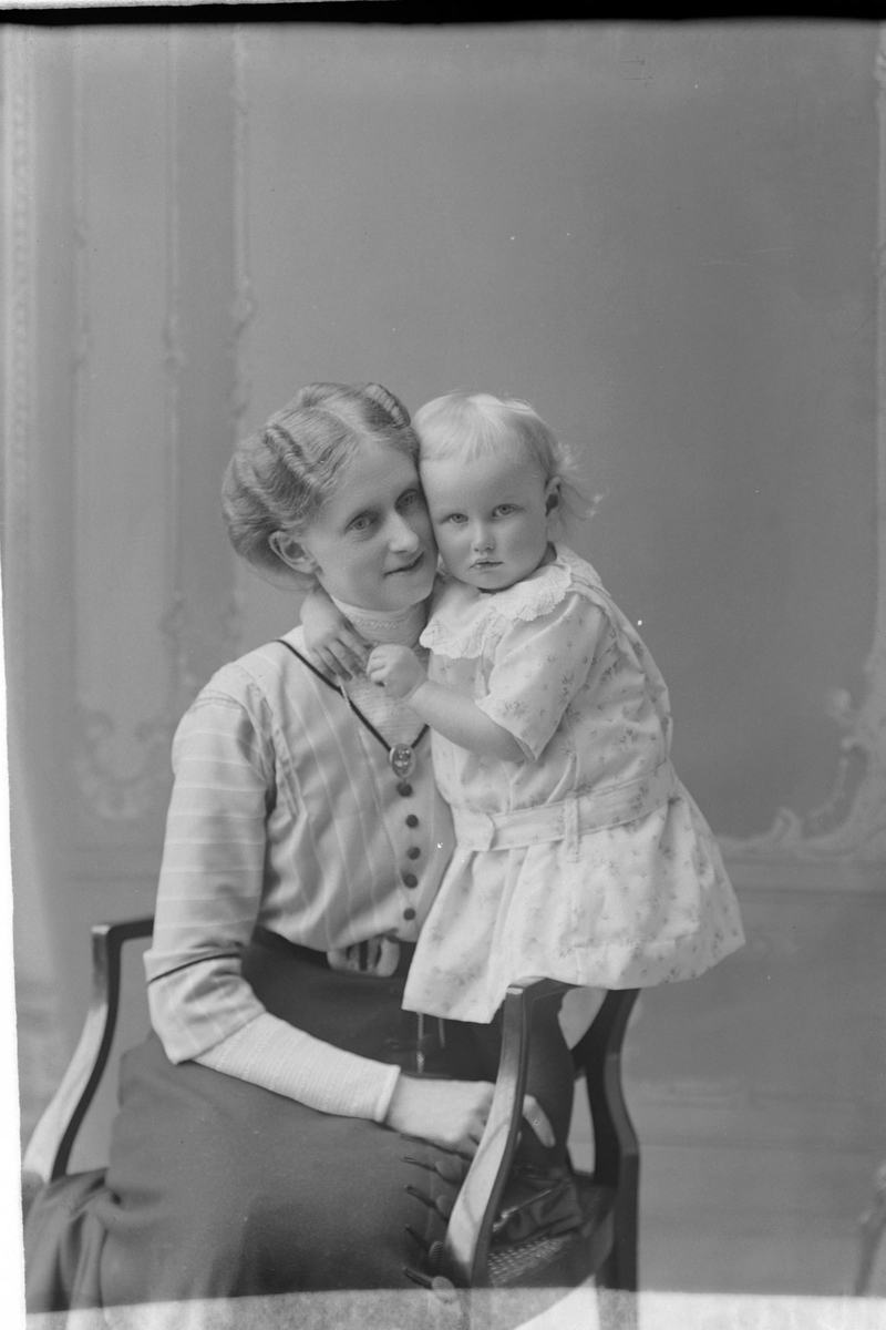 Studioportrett av en kvinne som klemmer et barn.